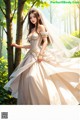 A woman in a wedding dress standing in the woods.