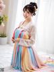 A woman in a colorful hanbok is posing for a picture.