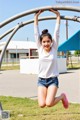 A young woman is jumping on a monkey bars.