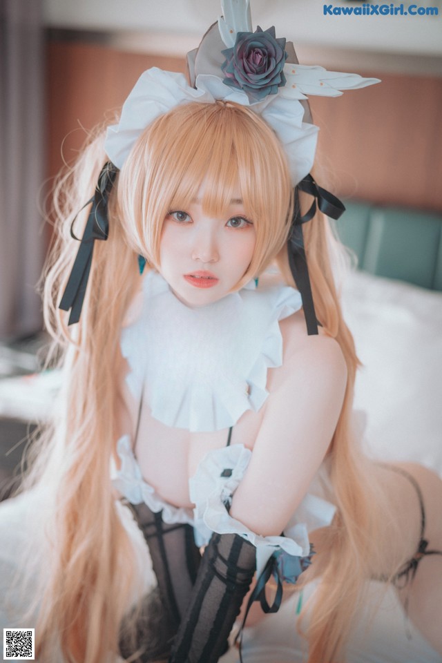 A woman with long blonde hair wearing a white dress and black stockings.