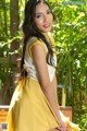 A woman in a yellow dress sitting on a bench.