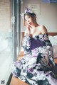 A woman in a kimono sitting on a window sill.