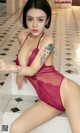 A woman in a red lingerie sitting on a white bench.
