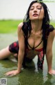 A woman in a red and black bikini laying in the water.