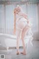 A woman in a white lingerie posing in a bathtub.