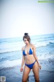 A woman in a blue bikini standing in the ocean.