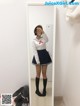 A woman in a sailor outfit taking a selfie in a mirror.