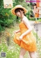 A woman in a yellow dress and a straw hat.