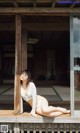 A woman in a white bikini laying on a wooden deck.