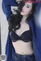 A woman in a black bra and jeans posing for a picture.