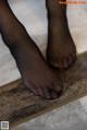 A close up of a person's feet on a tile floor.