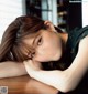 A woman laying on top of a wooden table.