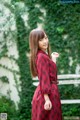 A woman in a red and black plaid dress posing for a picture.