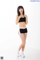 A woman in a black and white sports bra top and shorts.
