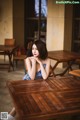 A woman sitting at a wooden table in a restaurant.