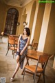 A woman sitting at a wooden table in a restaurant.