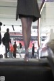 A woman walking down an escalator in a shopping mall.